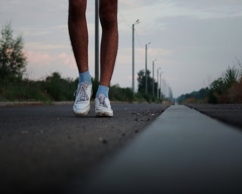 Person tying running shoes preparing for morning walk
